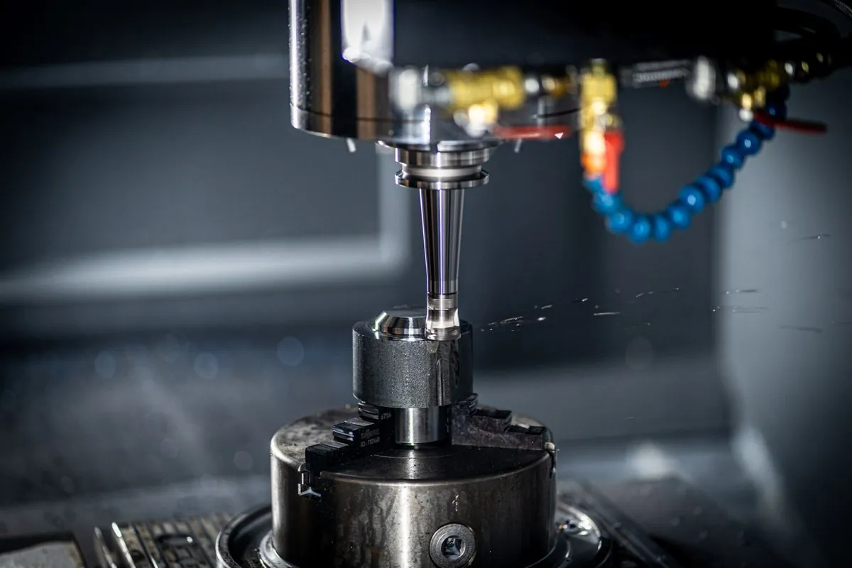 Stock photograph of a cutting tool machining a metal workpiece; not Omita equipment.