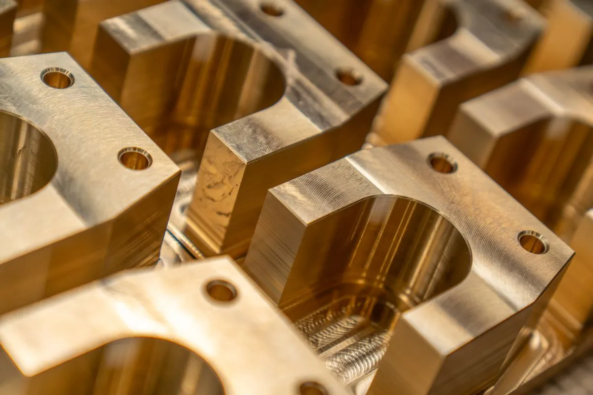 Stock photograph of machined metal blocks with recesses and holes; not Omita products.
